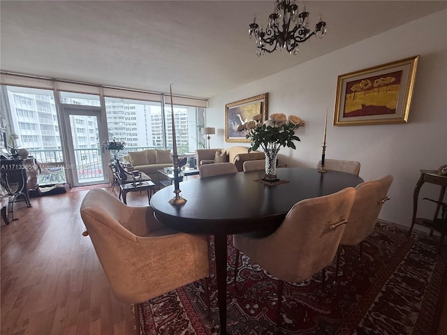 dining area featuring a wall of windows, a notable chandelier, and wood finished floors