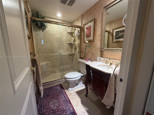 bathroom featuring vanity, a shower with door, and toilet