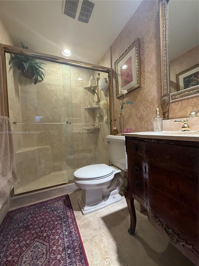 bathroom featuring an enclosed shower, vanity, and toilet