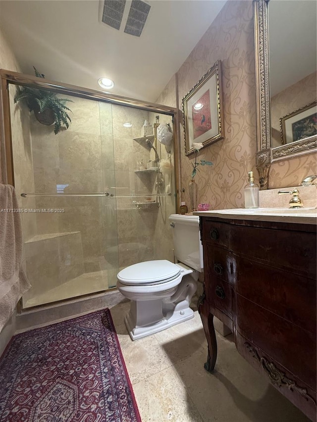 full bathroom with vanity, a shower stall, toilet, and wallpapered walls