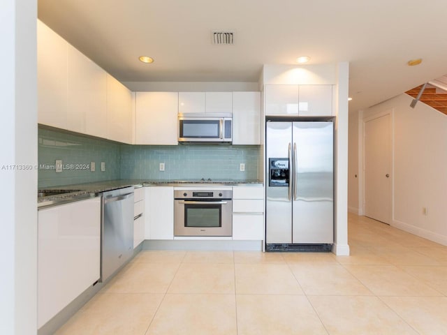 kitchen featuring white cabinets, light tile patterned flooring, and appliances with stainless steel finishes