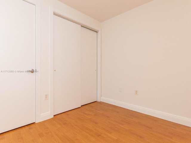 unfurnished bedroom featuring hardwood / wood-style floors and a closet