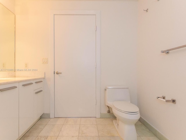 bathroom with tile patterned flooring, vanity, and toilet