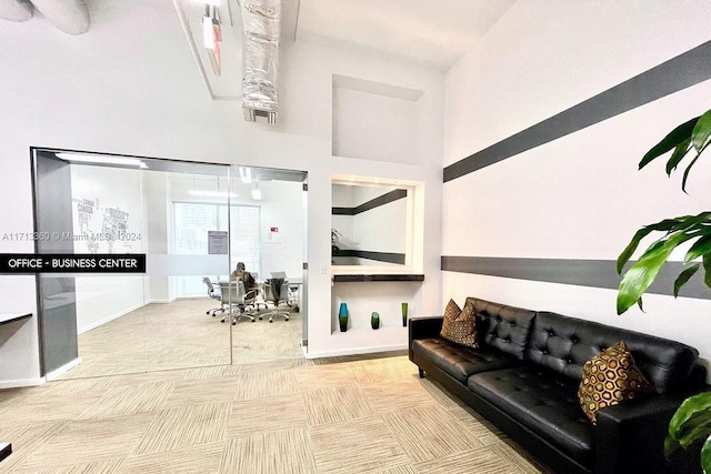 carpeted living room with a high ceiling