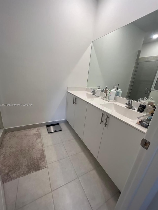 bathroom featuring vanity, tile patterned floors, and a shower with door