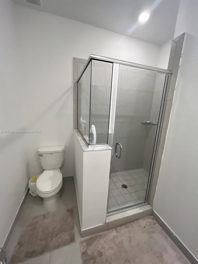 bathroom featuring an enclosed shower and toilet