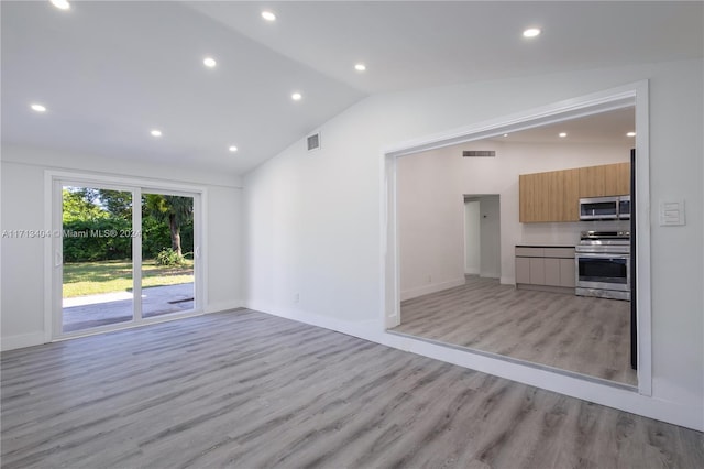 unfurnished living room featuring lofted ceiling and light hardwood / wood-style flooring