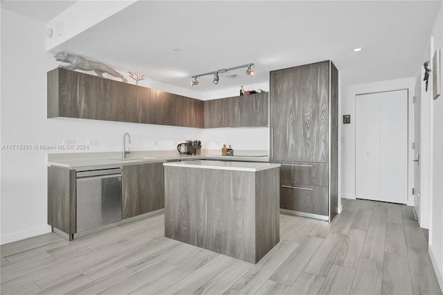 kitchen featuring a center island, sink, rail lighting, stainless steel dishwasher, and dark brown cabinets