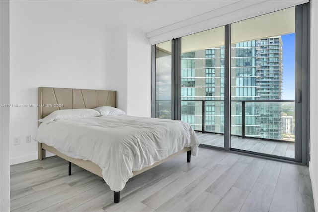 bedroom with access to exterior and light hardwood / wood-style flooring