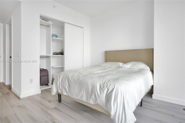 bedroom featuring light wood-type flooring and a closet