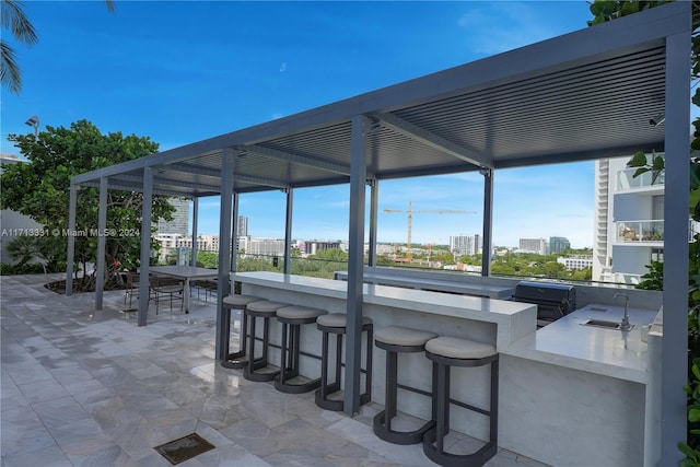 view of patio / terrace with exterior kitchen and a wet bar