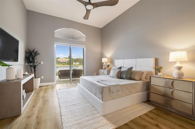 bedroom with access to exterior, ceiling fan, light hardwood / wood-style flooring, and vaulted ceiling