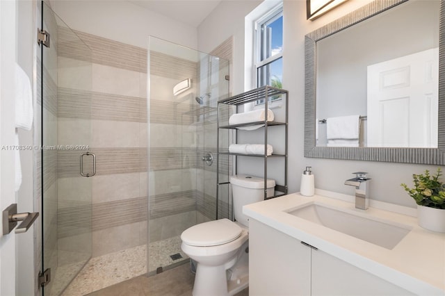 bathroom featuring vanity, toilet, and an enclosed shower