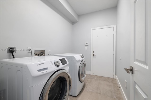 laundry area featuring washing machine and dryer and light tile patterned flooring