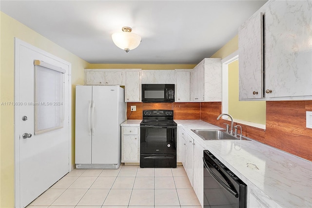 kitchen with black appliances, white cabinetry, sink, and light tile patterned floors