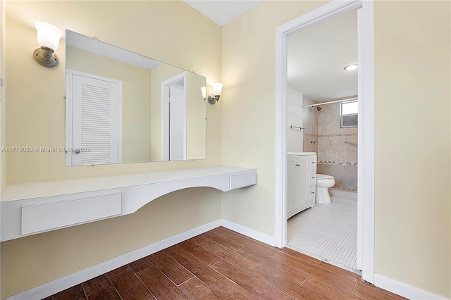 bathroom featuring tiled shower, vanity, and toilet