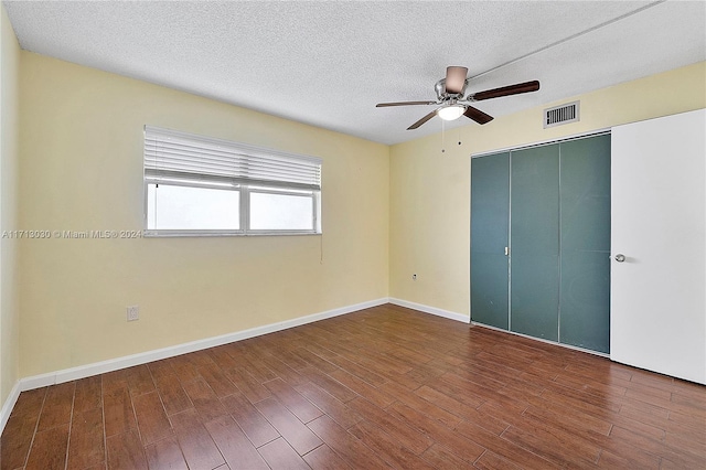 unfurnished bedroom with ceiling fan, wood-type flooring, a textured ceiling, and a closet