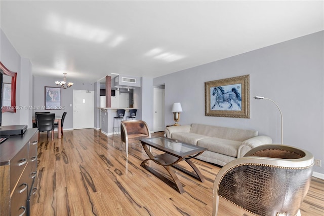 living room with light hardwood / wood-style flooring and a chandelier