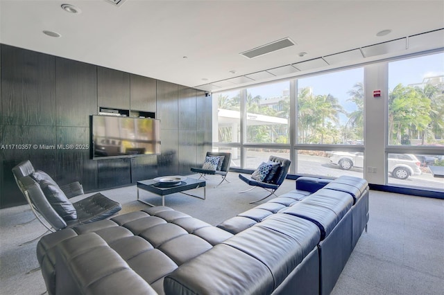 living room with expansive windows, light colored carpet, and plenty of natural light