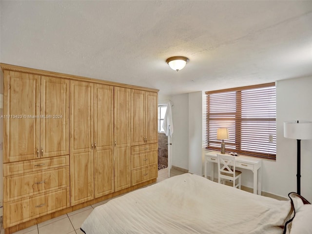 tiled bedroom featuring a textured ceiling