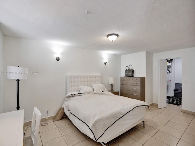 bedroom featuring a textured ceiling and light tile patterned flooring