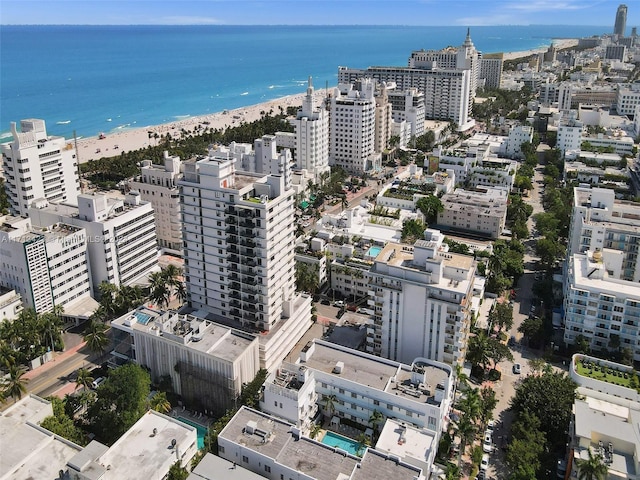 birds eye view of property featuring a water view and a beach view