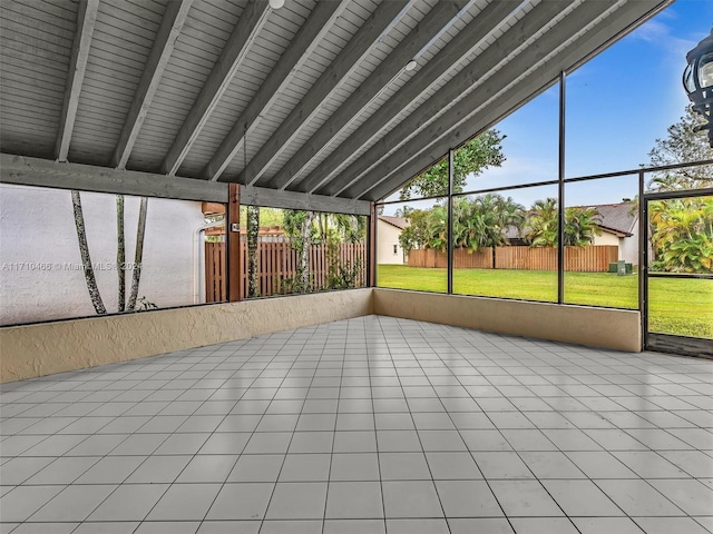 unfurnished sunroom featuring vaulted ceiling with beams