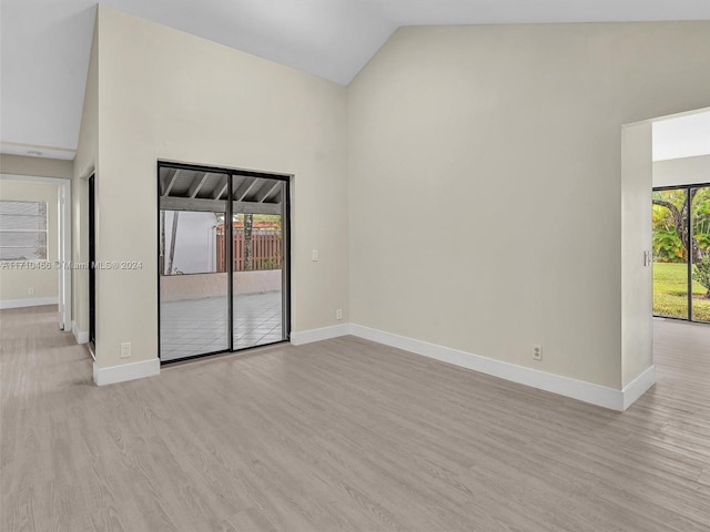 empty room featuring light wood-type flooring and vaulted ceiling