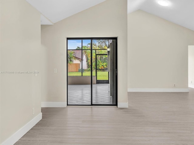 unfurnished room featuring light hardwood / wood-style floors and lofted ceiling