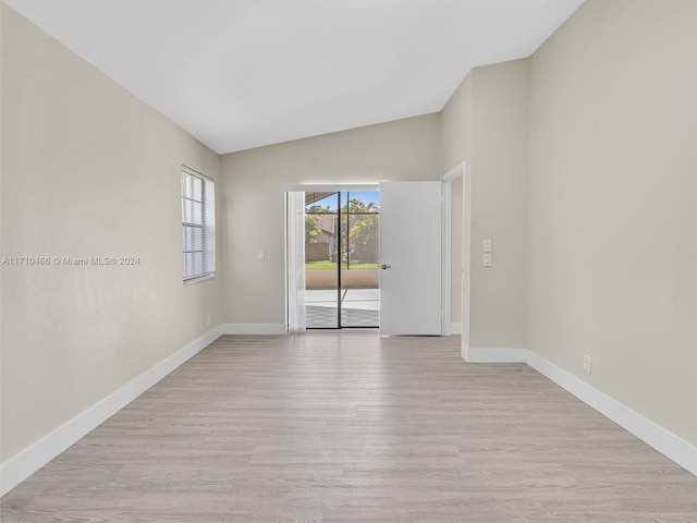 empty room featuring light hardwood / wood-style floors and vaulted ceiling