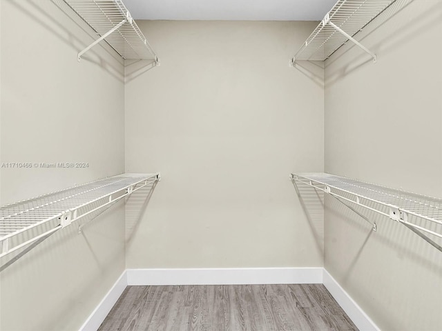 walk in closet with hardwood / wood-style floors