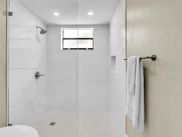 bathroom with toilet and a tile shower