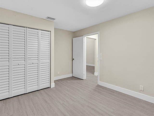 unfurnished bedroom featuring a closet and light hardwood / wood-style floors