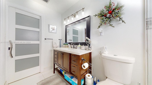 bathroom featuring tile patterned flooring, vanity, and toilet