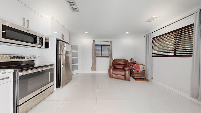 kitchen featuring white cabinets, light tile patterned floors, and stainless steel appliances