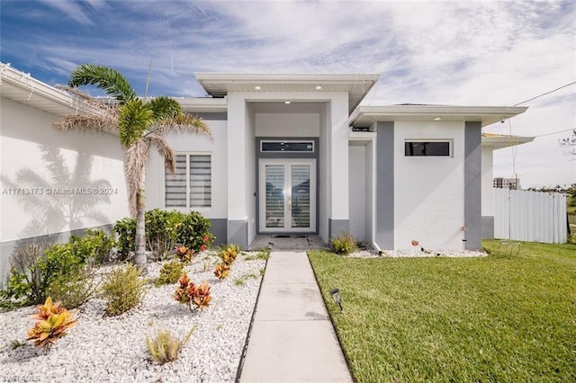 view of exterior entry with a yard