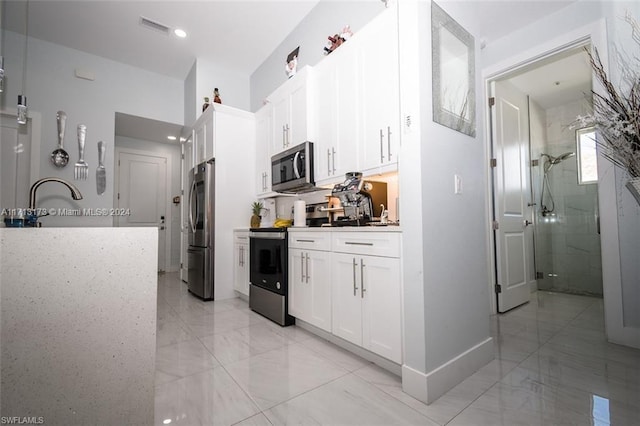 kitchen with white cabinets, sink, and appliances with stainless steel finishes