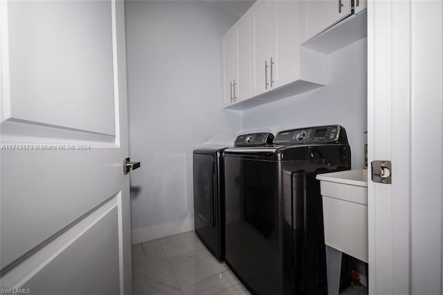 clothes washing area featuring cabinets, independent washer and dryer, sink, and light tile patterned floors