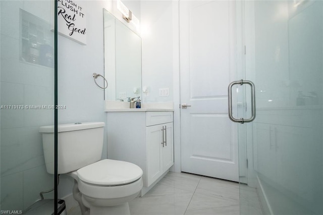 bathroom featuring vanity, an enclosed shower, and toilet