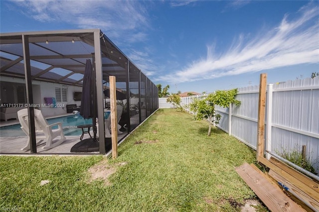 view of yard with a fenced in pool, glass enclosure, and a patio