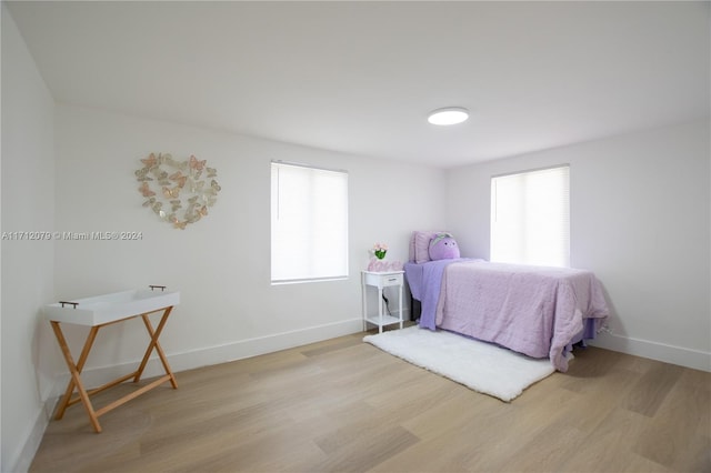 bedroom with light wood-type flooring and multiple windows