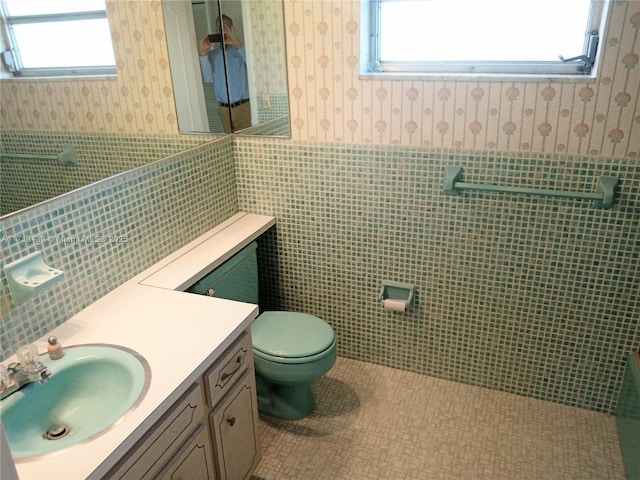 bathroom featuring tile patterned floors, toilet, tile walls, and vanity