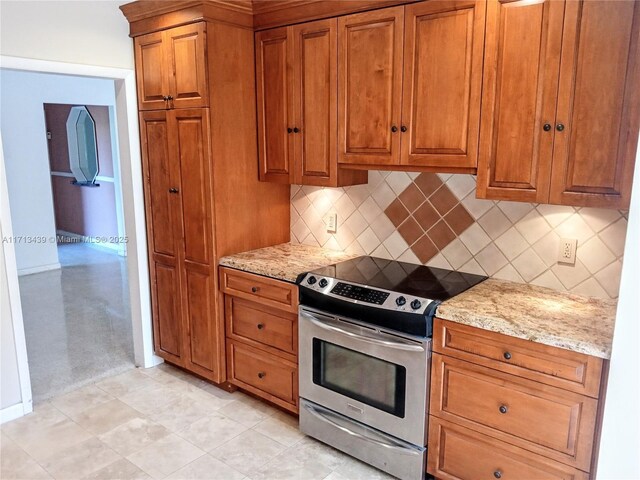 410 Miller Rd, Coral Gables, FL 33146 - kitchen featuring stainless steel electric range oven, brown cabinetry, decorative backsplash, and light stone countertops