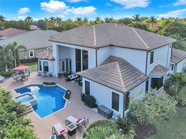 back of property with a pool with hot tub, an outdoor hangout area, and a patio