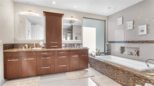 bathroom featuring tile patterned flooring, vanity, and a relaxing tiled tub