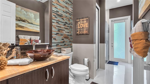 bathroom with tile patterned flooring, vanity, and toilet