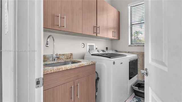 laundry area featuring washer and clothes dryer, sink, and cabinets