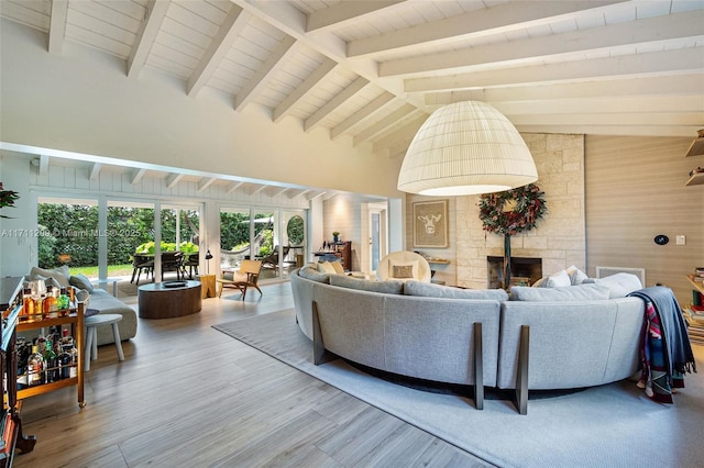 living room with a fireplace, vaulted ceiling with beams, and hardwood / wood-style flooring