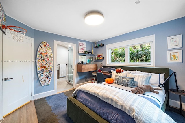 bedroom featuring ensuite bathroom and dark hardwood / wood-style floors