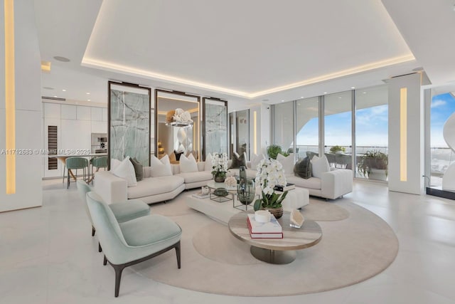 living room with expansive windows and a raised ceiling